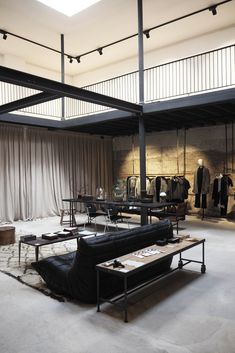 an empty room with lots of furniture and clothes hanging on the walls in front of it