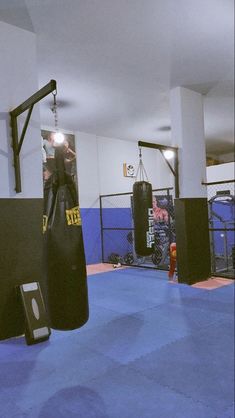 an empty gym with boxing gloves and punching bags