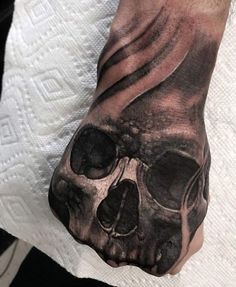 a hand with a black and white skull on it