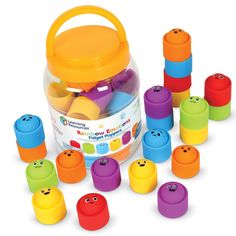 an assortment of colorful plastic toys in a container on a white background with lots of them