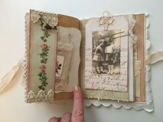 a hand holding an open book with pictures and writing on the pages that have been altered to look like old photos