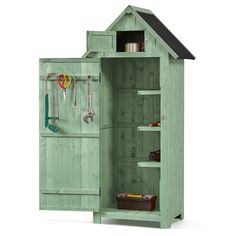 a green wooden toy house with tools in the door and shelves on each side,