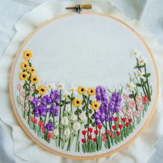 a cross stitch pattern with flowers and words in spanish on a white background, framed by a round frame