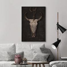 a living room with a couch, table and cow's skull on the wall