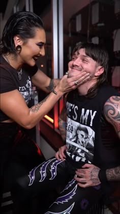 two people are posing for the camera with their hands over each other's mouths