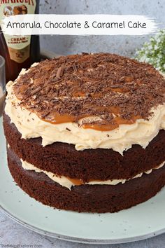 a chocolate cake with frosting and caramel toppings on a plate next to a glass of milk