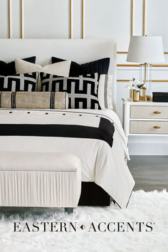 a white bed with black and gold accents