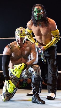 two men in wrestling gear standing next to each other