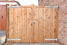 a wooden gate in front of a brick building