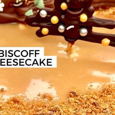 a close up of a cake with chocolate frosting and decorations on the top that says biscoff cheesecake