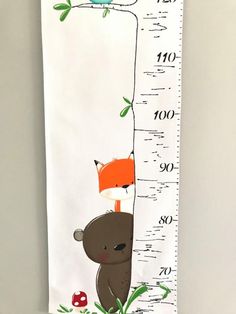 a growth chart with a bear and a fox on it's back, hanging from the wall