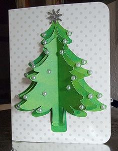 a card with a green christmas tree on the front and white polka dots on the back