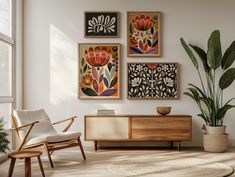 a living room filled with furniture and paintings on the wall next to a potted plant