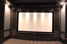 an empty theater room with no people in it and the projection screen is on display