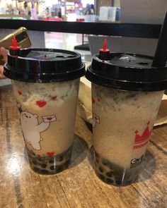 two coffee cups sitting on top of a wooden table