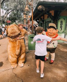 two children and an adult are standing in front of a mascot