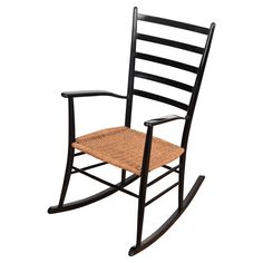 a wooden rocking chair with wicker seat and black frame, against a white background