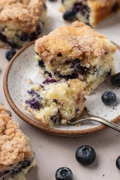 blueberry crumb muffins are on a plate with a spoon in it