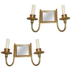 two wall sconces with mirrors and candles on them