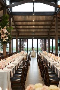 an indoor venue with tables and chairs set up for a formal dinner or wedding reception