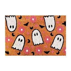 a door mat with ghost faces and hearts on it, in front of an orange background