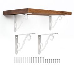 a wooden shelf with metal brackets and hooks on it's sides next to a pair of nails