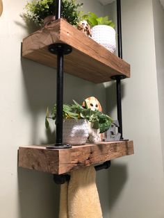 two wooden shelves with plants and towels on them