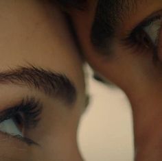 two people are looking at each other through the lens with their eyes wide open and one person's eye partially closed