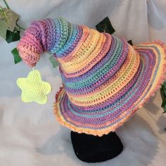 a multicolored crocheted hat on top of a black mannequin