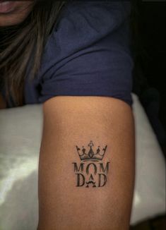 a woman with a tattoo on her arm that reads mom dad and has a crown