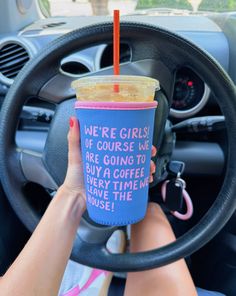 a person holding a cup in their hand while driving