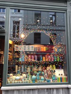 a store window with lots of different items in the front and behind it is an arch