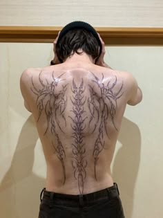 the back of a man with tattoos on his body