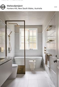 a white bathroom with a tub, toilet and sink in it's center area