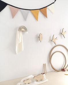 there is a white wall with some wooden birds on it and other decorations hanging from the wall