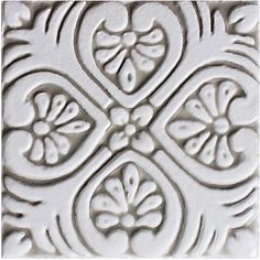 a close up view of an ornate pattern on a tile wall or ceiling in white