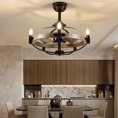 a chandelier hanging from the ceiling in a dining room with chairs around it