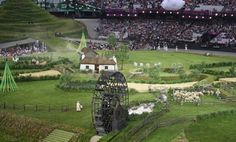 an aerial view of a field with sheep in it and people watching from the stands