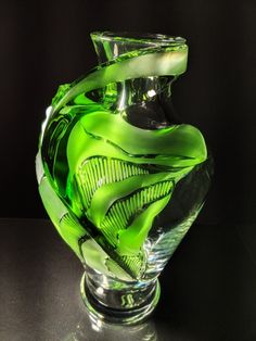 a green glass vase sitting on top of a table