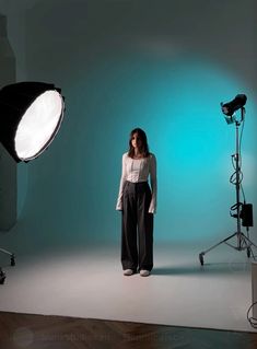 a woman standing in front of a camera and lighting equipment