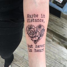 a woman with a tattoo on her arm saying maybe in distance, but never in heart