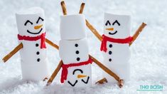 three marshmallow snowmen standing in the snow