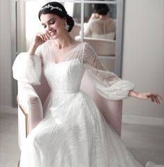 a woman sitting in a chair wearing a white dress