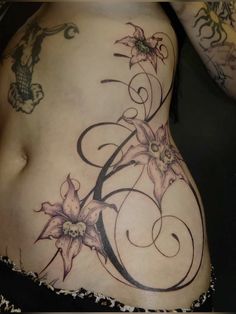 a woman's stomach with flowers and swirls on the side, in black and white