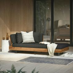 a couch sitting on top of a wooden floor next to a glass wall with sliding doors