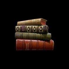 three books stacked on top of each other in front of a black background with the words,