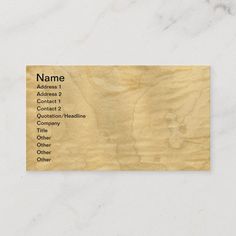 a wooden business card sitting on top of a white marble countertop with the words name address