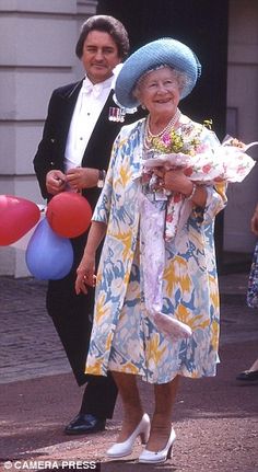 an older woman walking down the street with balloons and confetti in her hand