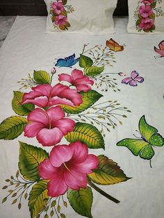 a bed with pink flowers and butterflies on it