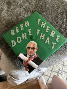 a green graduation cap with the words been there done that on it and a photo of a man in sunglasses